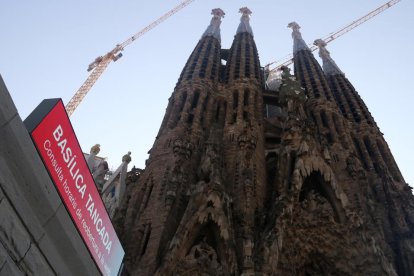 Fachada de la Sagrada Familia con un cartel que informa que el templo permanece cerrado (entre semana).