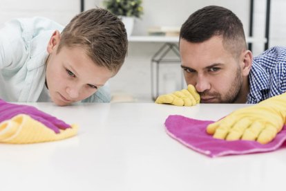 Imagen de un padre y un hijo limpiando una superficie.