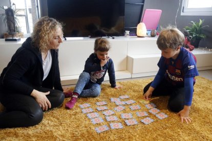 Plano general de Gemma, Biel y Arlet jugando a descubrir parejas durante el rato del confinamiento que se dedica a juegos.