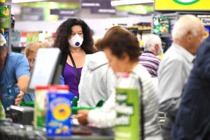 Imagen de archivo de una mujer en un supermercado de Australia con mascarilla.