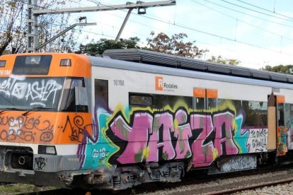 Cabecera del vagón de un tren de Rodalies lleno de pintadas.