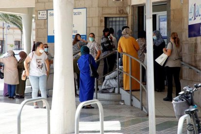 Diverses persones esperen el seu torn per sol·licitar els documents amb els quals demanar l'Ingrés Mínim Vital, el juny passat a Melilla.