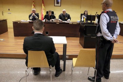 De espaldas, el acusado de intentar asesinar a una mujer y sus hijos en Banyoles.