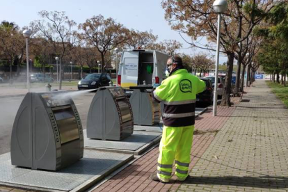 Un operari neteja un contenidor a Salou