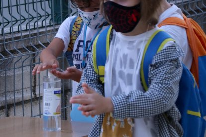 Dos alumnes de primària rentant-se les mans amb gel hidroalcohòlic a l'accés de l'escola Sant Llàtzer de Tortosa.