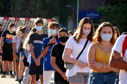 Alumnos de un instituto de Tarragona en hilera y con mascarilla.