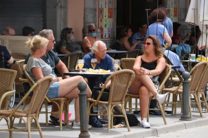 Un grupo de personas toma una cerveza en una terraza