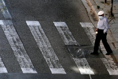 Una persona mayor paseando por la calle.