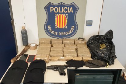 Els 22 paquets d'haixix, la pistola, els guants, els passamuntanyes i altres objectes que els Mossos d'Esquadra han requisat.