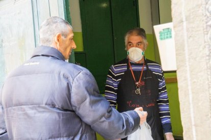 Un usuari ahir, agafant el menjar oferit per Càritas, en el programa Cafè i Caliu.