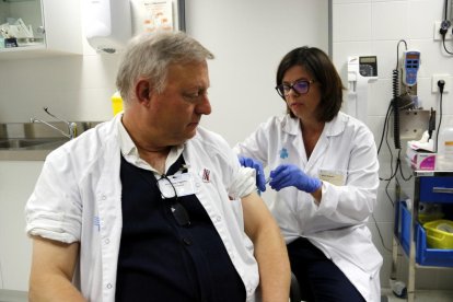 Un auxiliar de enfermería vacunándose por la gripe.