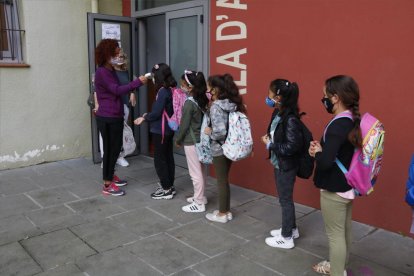 Alumnos de la escuela de Manlleu haciendo cola para cogerles la temperatura