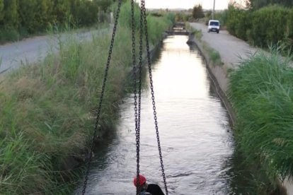 Serveis d'emergències traient el vehicle que la matinada del 2 d'agost del 2020 ha caigut al canal d'Urgell, a l'altura de Puigverd de Lleida, provocant una víctima mortal