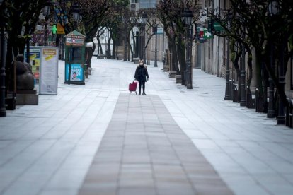 Una dona passejant pel carrer.