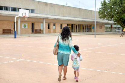 Una mare acompanya la seva filla a l'escola durant aquest final de curs atípic.