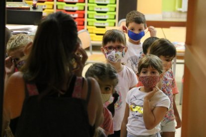 Pla mitjà d'un grup d'alumnes sortint de la seva classe amb les mascaretes posades a l'Escola Catalònia de Barcelona