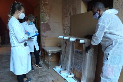 Diversos tècnics al costat d'algunes peces del Castell Monestir d'Escornalbou que es traslladaran provisionalment per l'inici de les obres de restauració.