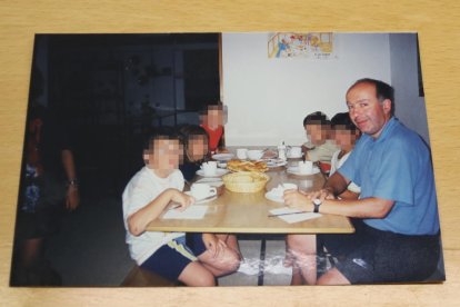 Una fotografía del mosén Josep Maria Font de colonias con varios niños, con la cara pixelada.