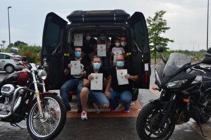 Algunos de los miembros de la entidad con todas las bolsas de comida y productos básicos preparadas para repartir.