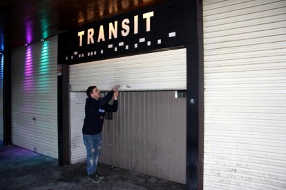 El gerent de la discoteca-pub Trànsit de Puigcerdà, Igor Roig, abaixant la persiana del seu local.