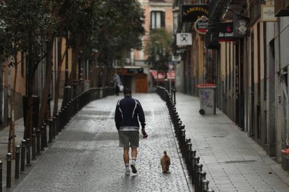 Un home camina amb el seu gos a Madrid