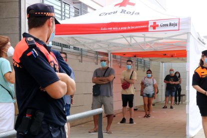 Cua de veïns del barri Llatí de Santa Coloma de Gramenet que esperen per fer-se la prova PCR.