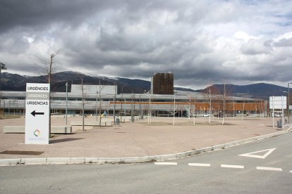 Exterior de l'edifici de l'Hospital de Cerdanya, on es veu en primer terme un cartell que indica on està la zona d'Urgències.