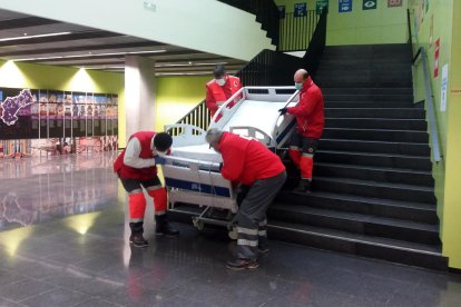 Efectivos de Cruz Roja bajando una cama de la Facultad de Enfermería de la URV.