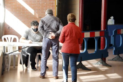 Pla mitjà on es pot veure dos veïns de Cervera accedint al punt de registre per fer-se la prova PCR en el marc del cribratge massiu que es fa a la ciutat per l'augment de casos de covid-19,