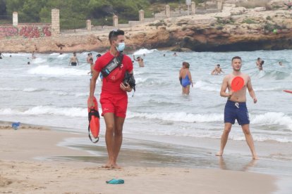 Pla sencer d'un socorrista de Creu Roja Tarragona passejant per la platja de l'Arrabassada