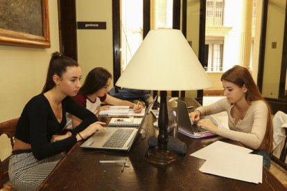 Tres estudiants utilitzant l'ordinador a l'interior d'un dels espais del Centre de Lectura.