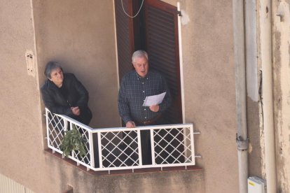 Pla mitjà d'un participant de la Setmana Santa de la Selva del Camp interpretant els temes de la processó de l'Agonia de Divendres Sant des del balcó de casa seva.