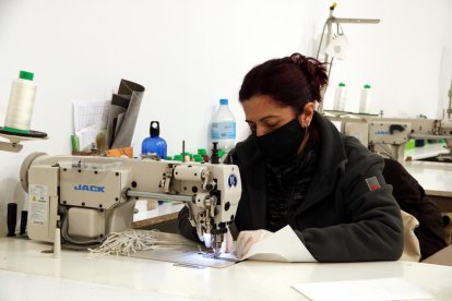 Una de les treballadores de la Tapisseria Nilcar confeccionant mascaretes