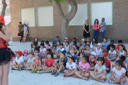 Imatge d'arxiu de diversos infants al casal del CEIP el Serrallo amb la regidora Carla Aguilar al fons.