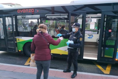 Un agent de protecció civil repartint mascaretes.