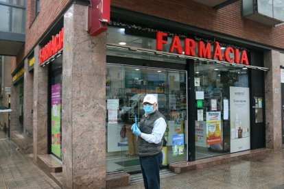 Un hombre sale de una farmacia con las recetas en la mano.