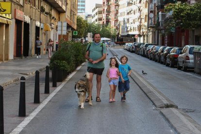 Una família passejant per la calçada al carrer Escultor Rocamora ahir a la tarda.