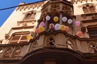 Pilar Fontana al balcó de casa seva rodejada de globus.