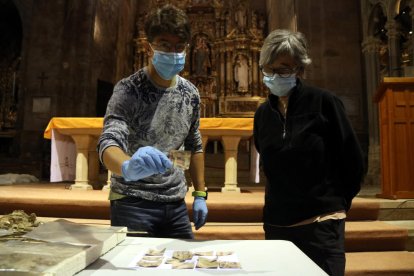 Plano medio del responsable del monasterio de Santes Creus, Joan Ibarz, mostrando uno de los fragmentos de naipes localizados, cerca de la arqueóloga Carme Subiranas.