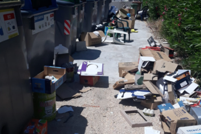 Imagen de la isla de contenedores llena de cajas y basura.