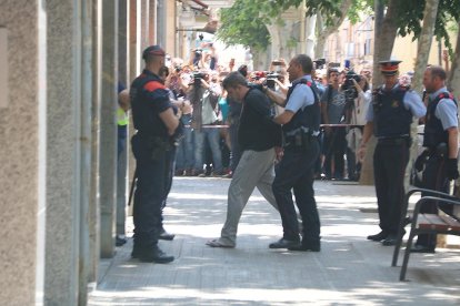 Plano abierto del momento en que los Mossos d'Esquadra llevan al detenido por el crimen de la menor de 13 años de Vilanova i la Geltrú hasta su domicilio para reconstruir los hechos.