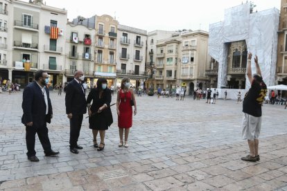 La periodista Coia Ballesté simulando encender la Tronada y un hombre recreando con movimiento y sonido el estallido de uno de los machos del momento álgido del acto.