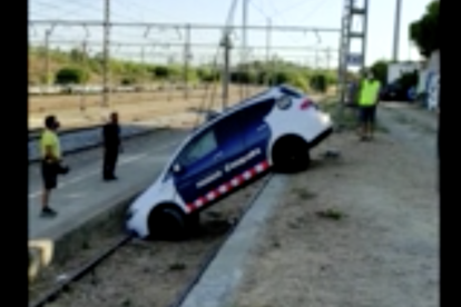 Imatge de la retirada del vehicle policial de les vies del tren.