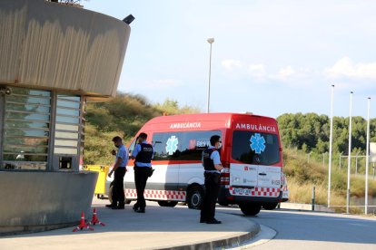 Plano general de la ambulancia que llevaba a Fèlix Millet al lado de los mossos d'Esquadra de la entrada de la prisión de Brians 2.