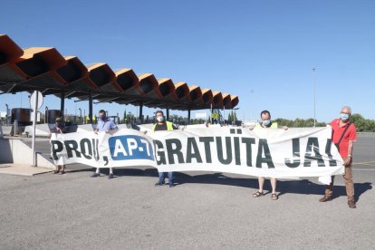 Pla general de membres de la plataforma 'Prou! AP-7 Gratuïta Ja!' en l'acció a l'accés de l'autopista AP-7 de Salou.