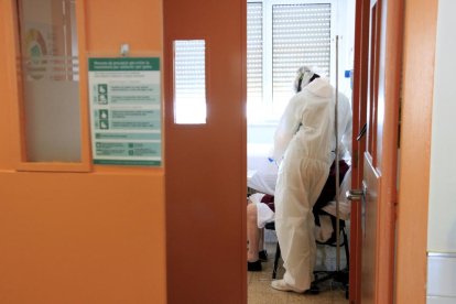 Una professional sanitària al costat d'un pacient amb covid-19 que parla amb la seva família a través d'una tauleta a l'Hospital del Mar.