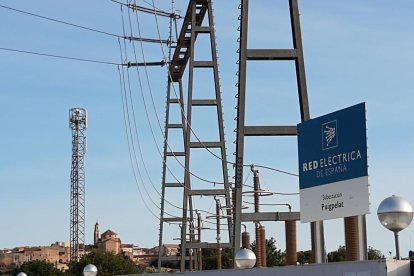 La subestació elèctrica de Puigpelat (Alt Camp), d'un camp de vinyes al costat, i del poble al fons