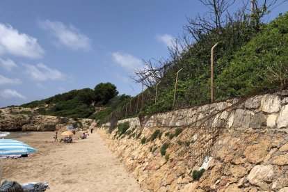 Imatge del mal estat en què es troba la tanca que separa la via del tren de la platja Llarga, molt estreta per les crescudes del mar.