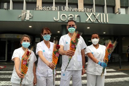 Quatre professionals sanitaris del Joan XXIII de Tarragona amb la seva rosa solidària a les mans.