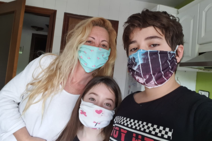 Imagen de la Paola y sus hijos con mascarillas hechas por ella.